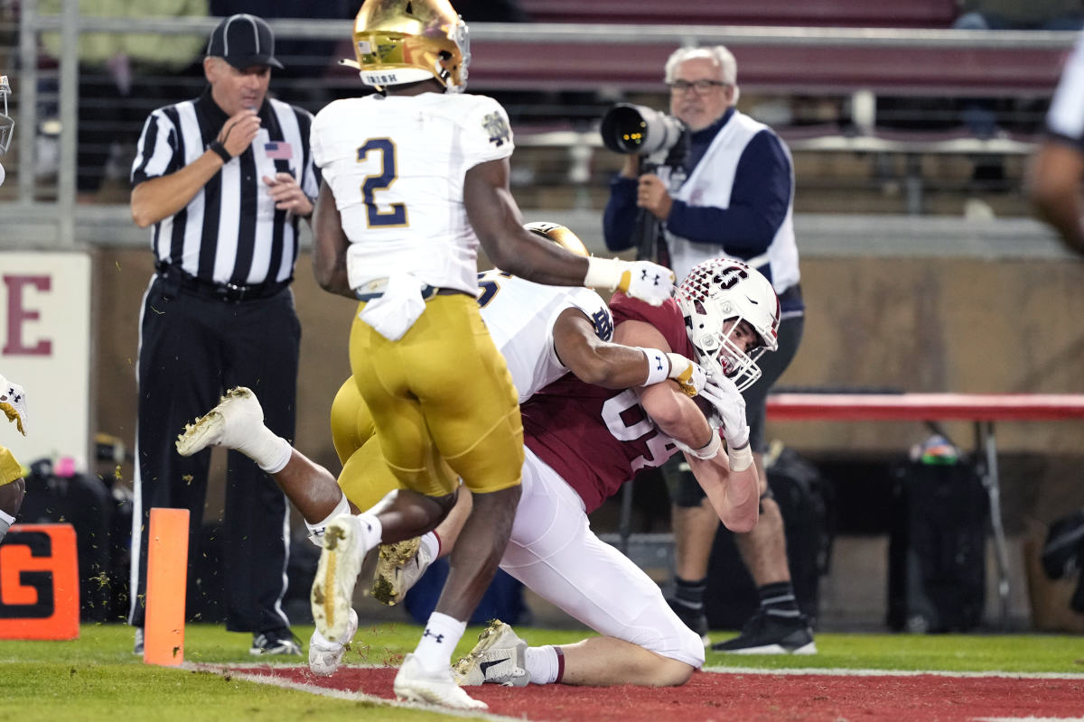 Nov 27, 2021; Stanford, California, USA; Stanford Cardinal tight end Benjamin Yurosek (84) scores a touchdown while being tackled by Notre Dame Fighting Irish cornerback Clarence Lewis (6) during the fourth quarter at Stanford Stadium. (Darren Yamashita / USA TODAY Sports).